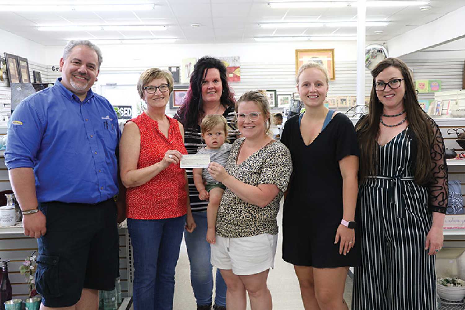 From left are Terry Grant and Jacqui Beckett with the Moosomin Visual Arts Centre committee accepting a $2,000 donation from Samantha Campbell (holding Blake Campbell), Marguerite Osborne, Jaedyn Moore, and Brianna Browman with the Moosomin Thrift Store.
